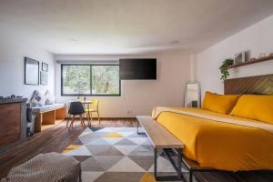 una camera con letto giallo e tavolo di La Fábrica #3 Kokerei a Valle de Bravo