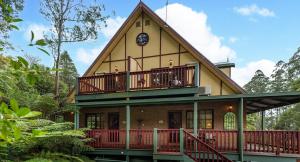 Una casa con un reloj al costado. en Mountain Lodge, en Mount Dandenong