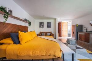 una camera con un grande letto giallo e una cucina di La Fábrica #3 Kokerei a Valle de Bravo Altre 17 foto