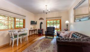 sala de estar con sofá y mesa en Mountain Lodge, en Mount Dandenong