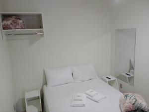 uma cama branca num quarto com caixas em Pousada Chácara VIVALLI em Holambra