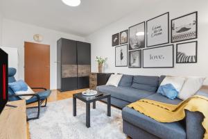 salon z niebieską kanapą i stołem w obiekcie Air conditioned - 2 Room Apartment Ružinov w Bratysławie