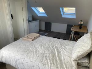 a bedroom with a bed with two skylights in it at 87 classic comfort in harrow in Hatch End