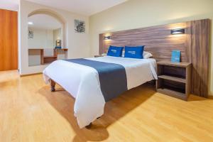 a large bedroom with a large bed with blue pillows at Premier Tambo in Arequipa