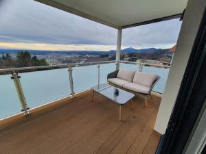 a balcony with a chair and a table on a balcony at Apartment Weizblick in Oberdorf bei Thannhausen