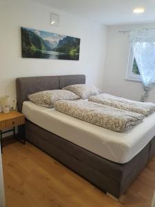 a bed in a bedroom with a picture on the wall at Apartment Weizblick in Oberdorf bei Thannhausen