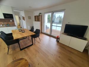 a kitchen and dining room with a table and a television at Apartment Weizblick in Oberdorf bei Thannhausen