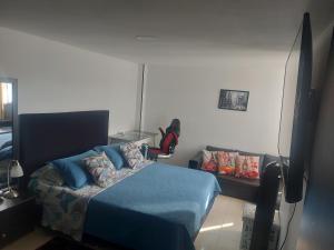 1 dormitorio con 1 cama azul y TV en RentafrankitoS Ibagué TOP, en Ibagué