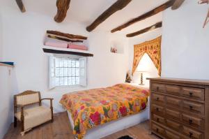 a bedroom with a bed and a dresser and a window at Rural House, heated pool & steam room, Casa Aloe. in Atalbéitar