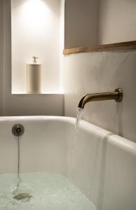 una bañera con agua que sale de un grifo en Le Roitelet - Suite d'hôtes privative, en Montcavrel