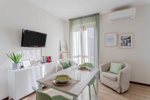 un salon blanc avec une table et des chaises dans l'établissement Casa Caterina - Pavia City - by Host4U, à Pavia