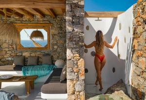 Onar Suites & Villas في كارافوستاسيس: امرأة في غرفة تقفز في الجدار