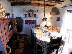 a dining room with a table with chairs and a fireplace at Rural House, heated pool & steam room, Casa Aloe. in Atalbéitar