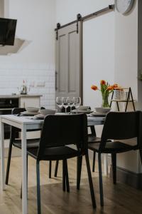 a dining room with a table with chairs and glasses at BlueSeaView Apartment with fabulous sea views in Newcastle