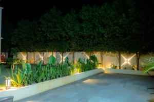 a fence with lights and plants on it at night at Villa Vista - with Pool & Jaccuzi in Kundakal