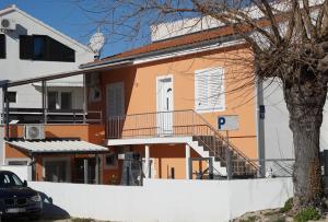 a house with a staircase in front of it at Apartmani Skledar in Vodice