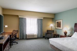 a hotel room with a bed and a desk and a window at Hilton Garden Inn Billings in Billings