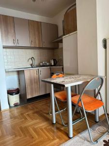 uma pequena cozinha com uma mesa e duas cadeiras em Apartman Edita em Sarajevo