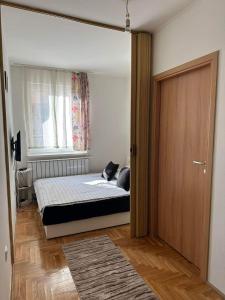um quarto com uma cama, uma janela e uma porta em Apartman Edita em Sarajevo