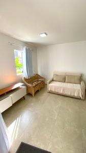 Habitación blanca con cama y ventana en Casa Solar - Praia do Francês en Marechal Deodoro