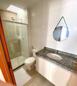 a bathroom with a toilet and a sink and a mirror at Casa Solar - Praia do Francês in Marechal Deodoro