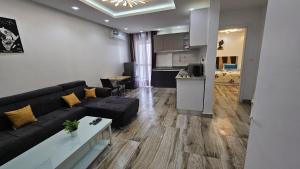a living room with a black couch and a kitchen at Superbe Appartement à Ngor in Dakar