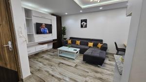 a living room with a couch and a flat screen tv at Superbe Appartement à Ngor in Dakar