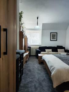 1 dormitorio con 2 camas y sofá en Milano Apartman ****, en Brzeće