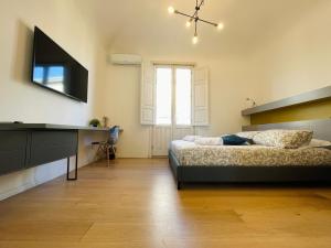 - une chambre avec un lit et une télévision à écran plat dans l'établissement Dimora del Mercante, à Catane