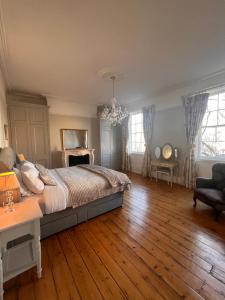 a bedroom with a large bed and a chandelier at No2 Clarence grade II Regency townhouse short walk to racecourse and town centre in Cheltenham