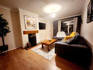 a living room with a couch and a table at Bridge House Sleeps 10 max in York, Free Parking in York
