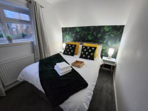 a bedroom with a white bed with black and yellow pillows at Bridge House Sleeps 10 max in York, Free Parking in York