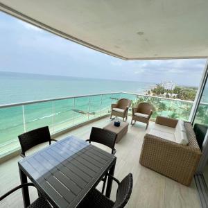 d'un balcon avec une table et des chaises donnant sur l'océan. dans l'établissement Hermoso Apartamento frente al mar, 4 habitaciones - Apto 801, à Coveñas