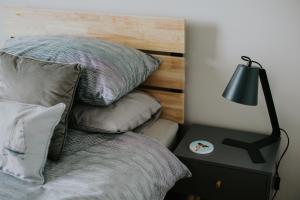 a bed with pillows and a lamp on a night stand at BlueSeaView Apartment with fabulous sea views in Newcastle