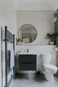 BlueSeaView Apartment with fabulous sea views في نيوكاسل: حمام مع مرحاض ومغسلة ومرآة