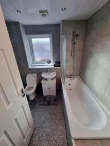 uma casa de banho com uma banheira, um WC e um lavatório. em Rise at the International Wall Belfast em Belfast