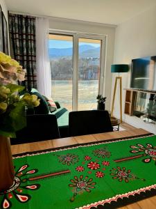 salon z zielonym dywanem i kwiatami w obiekcie Panorama Karkonoszy - Apartamenty KOMFORT z widokiem na Śnieżkę i Aquapark w mieście Karpacz
