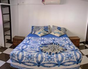 een slaapkamer met een blauw en wit bed met kussens bij Apartamento en Rodadero in Santa Marta