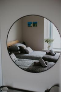 a mirror reflecting a bedroom with two beds at BlueSeaView Apartment with fabulous sea views in Newcastle