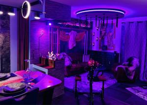 a room with purple lighting and a table and chairs at Love And Sex Room in Ferney-Voltaire