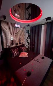 ein Schlafzimmer mit einem Bett mit roter Beleuchtung in der Unterkunft Love And Sex Room in Ferney-Voltaire