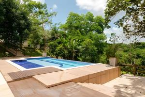 una piscina in un cortile alberato di Sítio em Aldeia com piscina e lago a Camaragibe