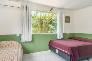 a bedroom with a bed and a window at Sítio em Aldeia com piscina e lago in Camaragibe