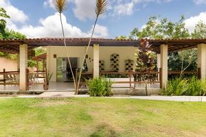 a home with a patio and grass at Sítio em Aldeia com piscina e lago in Camaragibe