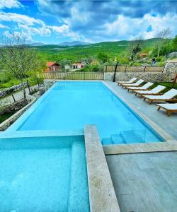 une grande piscine avec des chaises longues dans l'établissement Holiday Home Mela, à Srijane