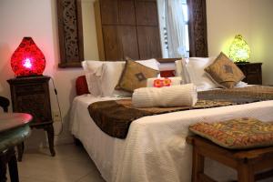 a bedroom with two beds and a red lamp at Casa Petunia Pousada Boutique in Salvador