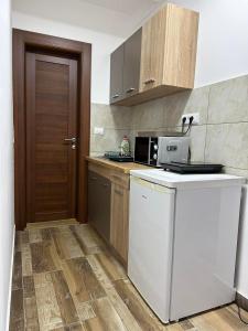 a kitchen with a white refrigerator and a microwave at Apartmani Liman Kopaonik in Kopaonik