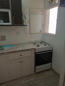 a kitchen with a stove and a counter top at Confortable departamento en Retiro in Buenos Aires