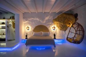 a bedroom with a bed and a rock wall at Onar Suites & Villas in Karavostasi