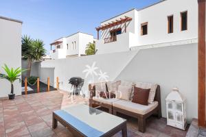 a patio with a couch and a table at Casa del Mar - Piscina y Jacuzzi Privado in Costa Teguise